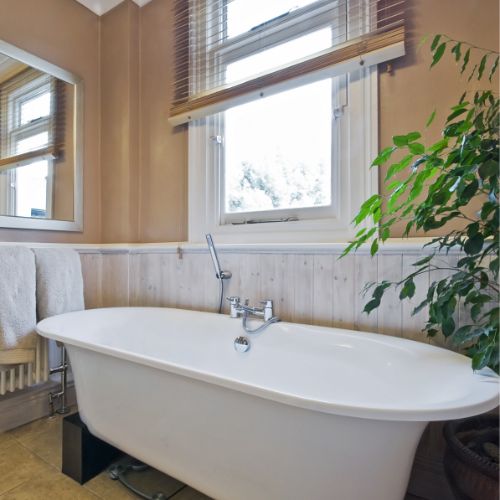 beige painted bathroom with white tub