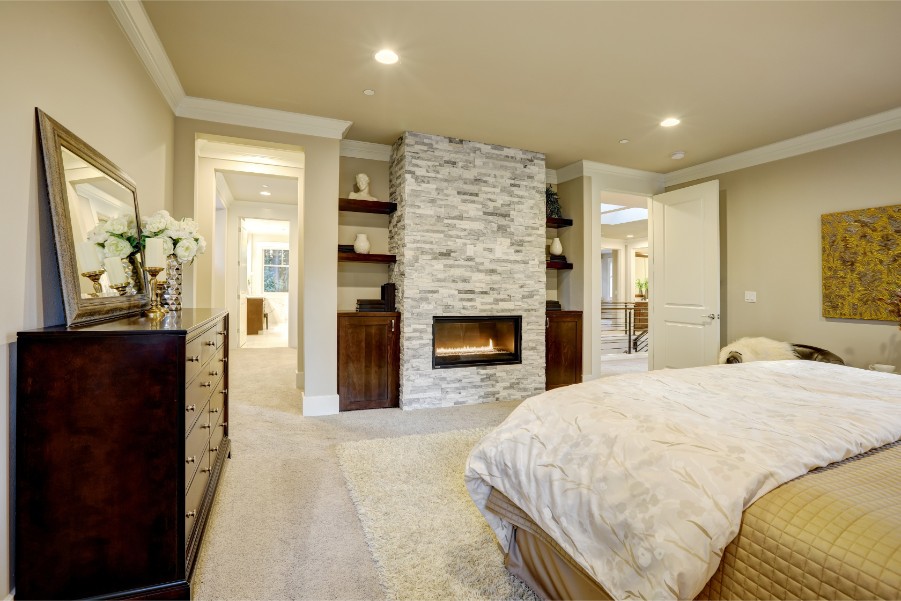 bedroom with brick fireplace and crown molding
