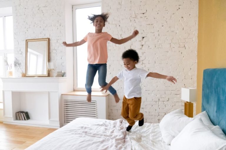 children jumping white bedroom