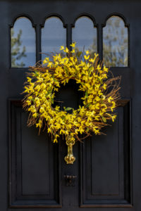 A springtime wreath made with twigs and forsythia spring flowers.