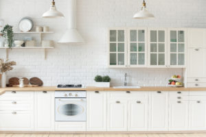 Kitchen interior with whitewashed brick walls, modern furniture, wooden countertop