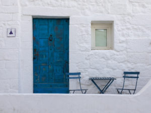 Exterior home in whitewash with blue door